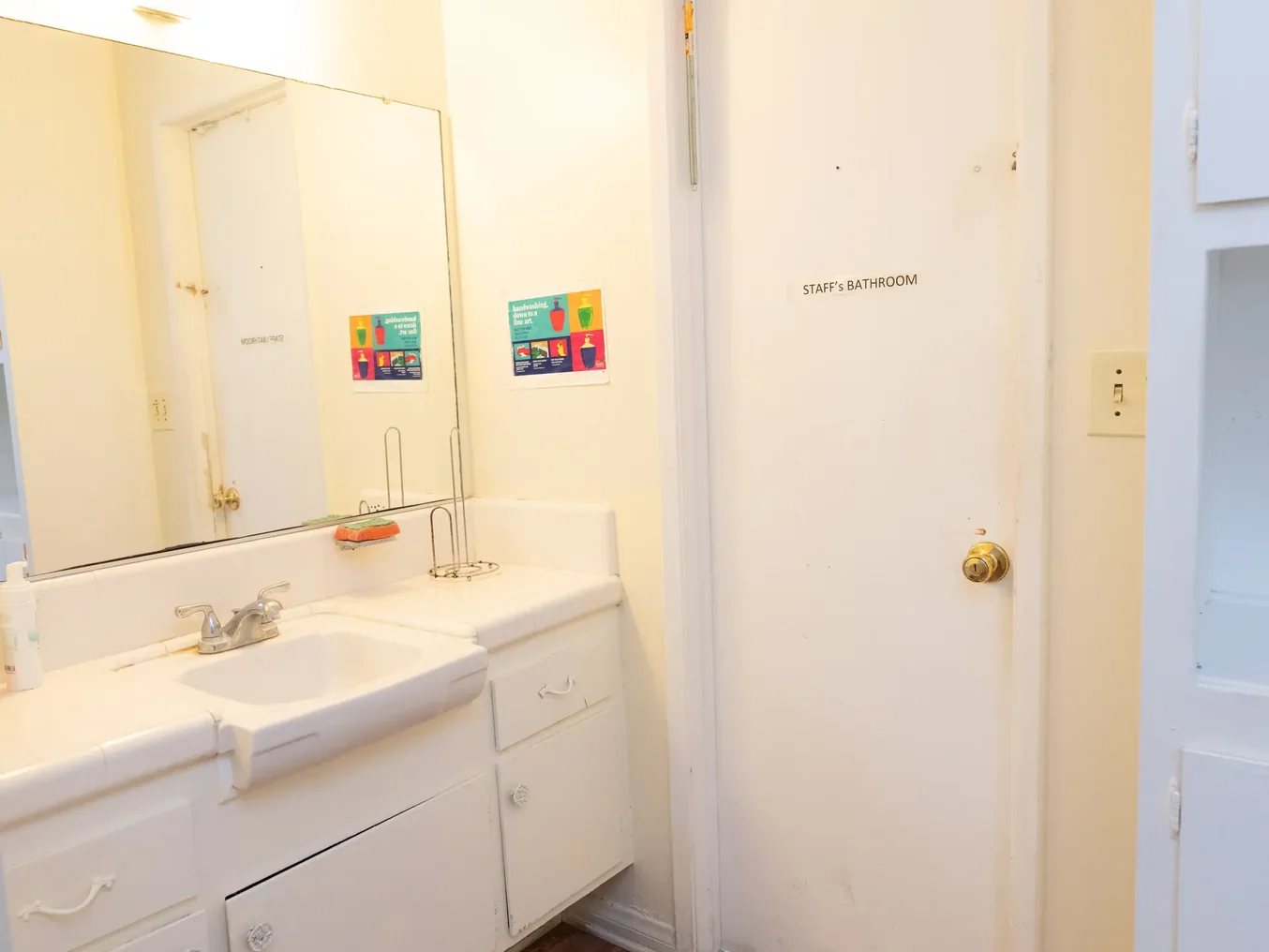 Clean staff bathroom with white vanity and sink in residential care facility